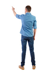 Back view of a man in jeans points his hand upwards.