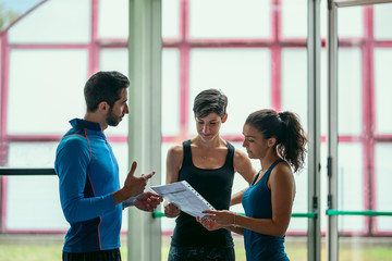 Three looking at clipboard with fitness.