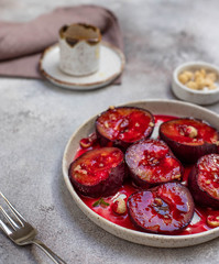 baked colorful plums with honey, cinnamon and nuts. healthy dessert. light background