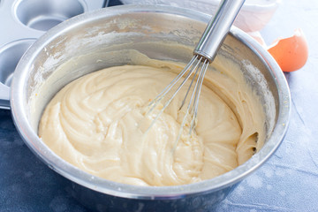 Raw cupcake dough in a metal bowl with a metal whisk, horizontal - Powered by Adobe
