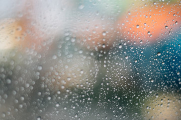 Blurred rainy window with red bokeh light