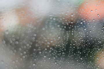 Blurred rainy window with red bokeh light