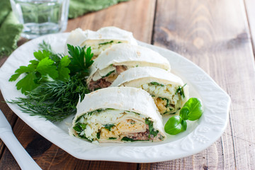 Lavash roll with canned saury, cheese and eggs, selective focus