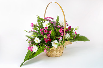 Bouquet of flowers in basket isolated on white.