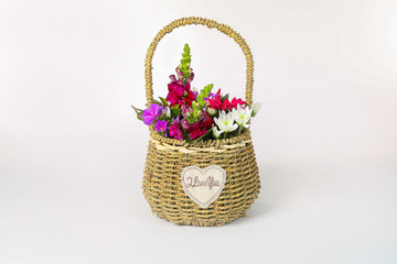 Flowers in a basket isolated on white.