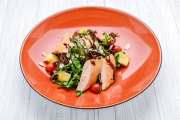 Spring salad. Wooden table background.