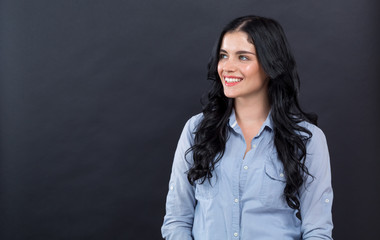 Happy young woman on a black background