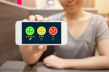 Customer Service Experience and Business Satisfaction Survey. Woman choose face smile on smart phone