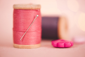 Spool with pink cotton thread closeup. Selective focus. Homemade concept.