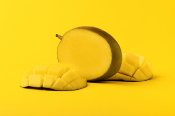 mango fruit with mango sliced cubes on yellow background