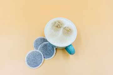 Kaffeetasse mit Kaffee und Kaffeepads auf orangefarbenen Hintergrund