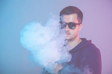 vaping man holding a mod. A cloud of vapor.
