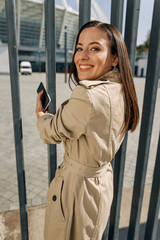 Charming young woman standing near metal support