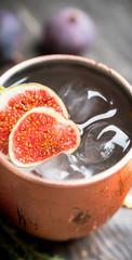 Moscow mule cocktail with figs and thyme on the rustic background. Selective focus. Shallow depth of field.
