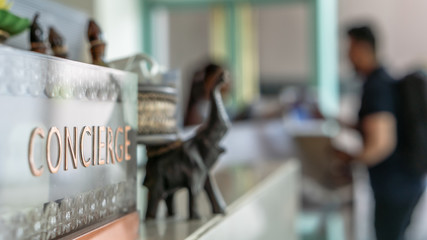 Concierge service counter of hotel, restaurant or apartment's front desk in luxury reception hall with staff working for serving tourist guest or check-in customers