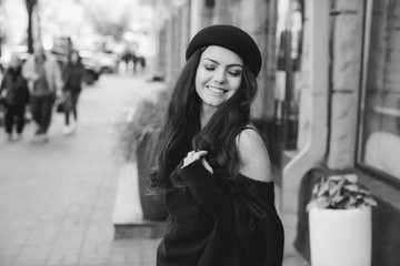 Fototapeta premium beautiful brunette woman dressed in retro style walking around the city. black and white