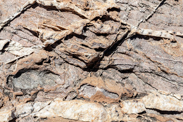 Textura da superfície da rocha natural, onde você pode ver as camadas de rocha e linhas de cristais brancos formados ao longo do tempo.