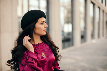 beautiful brunette woman in retro hat walking around the city. copy space