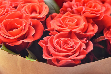 Red roses background. Bouquet beautiful red roses with selective focus in craft paper. Luxury bouquet made of amazing red roses. Valentines Bouquet of red roses. Present for Mother’s Day. 
