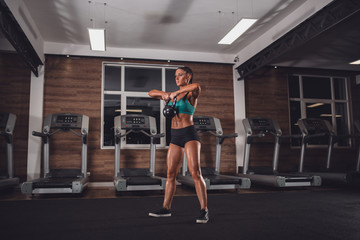 Fototapeta na wymiar Fit girl with kettle-bell exercise in gym