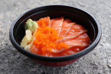 Fresh Salmon slices Include Shrimp eggs Pickled Ginger Wasabi In a black bowl , nutrition delicious ready for eat closeup  on stone background