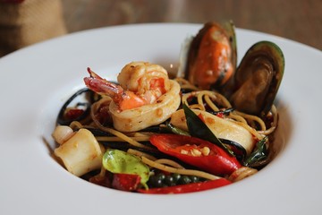 seafood Spaghetti in white plate on wooden table