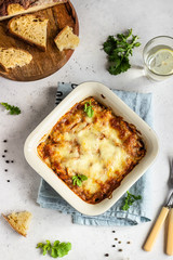 Baked gratin with chicken, vegetables in a tomato sauce with cheese. Chicken casserole in a ceramic dish.