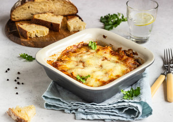 Baked gratin with chicken, vegetables in a tomato sauce with cheese. Chicken casserole in a ceramic dish.