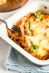 Baked gratin with chicken, vegetables in a tomato sauce with cheese. Chicken casserole in a ceramic dish.