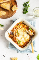 Baked gratin with chicken, vegetables in a tomato sauce with cheese. Chicken casserole in a ceramic dish.