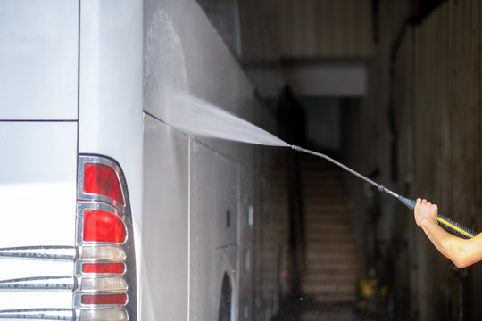 Bus Get Washed From A Washer With Water Jet In Garage 