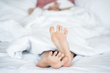 Fototapeta na wymiar Female lying in bed under the blanket