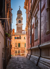 Fototapeta na wymiar Traditional street, church and colorful Venetian houses in Venice, Italy.