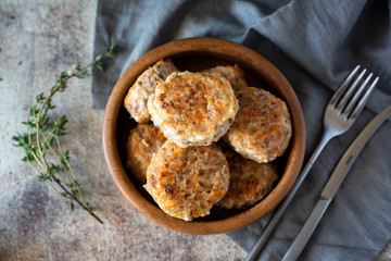 Pork cutlets on a beautiful wooden plate on a gray background