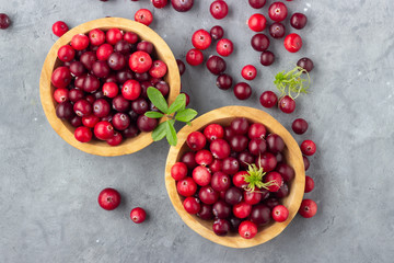 Wild northern berry - red cranberries on gray stone background. Top view.