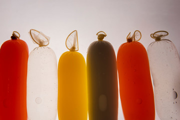 Condoms filled with colorful water, isolated on a white background.