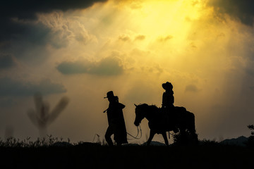 Obraz na płótnie Canvas Cowboy silhouette on a horse during nice sunset