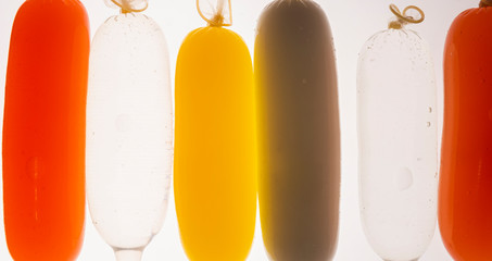 Condoms filled with colorful water, isolated on a white background.