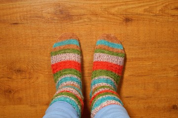 woolen socks on wooden floor, Legs in knitted socks as a symbol of country life, winter cosy scene