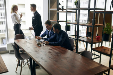 young people in formal clothes are spending time at the office with modern interior.