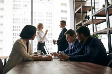 attractive two guys consulting female client at workplace, two colleagues discussing a problem in the background of the photo