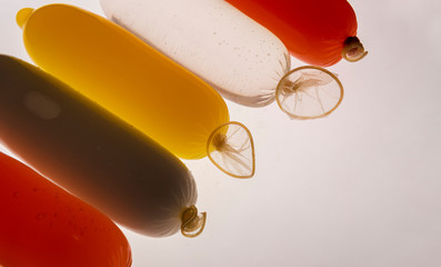 Condoms filled with colorful water, isolated on a white background.
