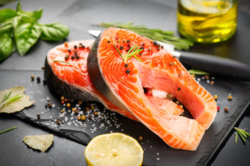 Salmon. Raw Trout Red Fish Steak served with Herbs and Lemon and olive oil on slate. Cooking Salmon, sea food. Healthy eating concept