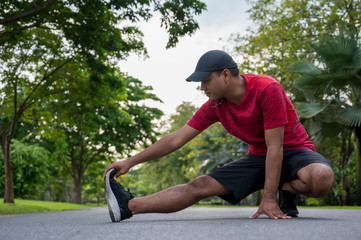 Young fitness man runner stretching before run healthy lifestyle and sport concepts