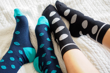 Young couple posing for a selfie feet wearing blue and white polka dotted socks. Landscape format.