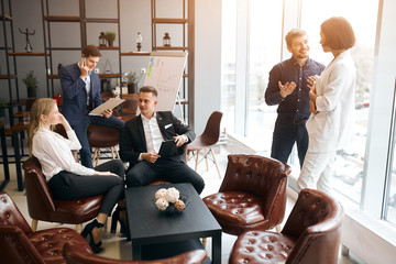 young relaxed positive people in formal stylish clothes having a rest at workplace, busy atmosphere in the office room
