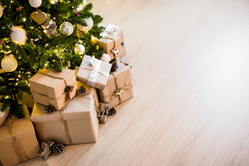 christmas tree and heap of gift boxes - copy space over wooden floor background