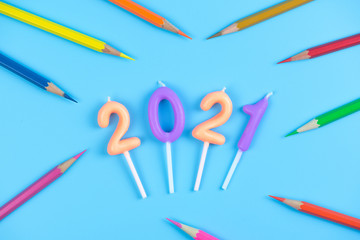 2021 birthday candle and color pencil on light blue background
