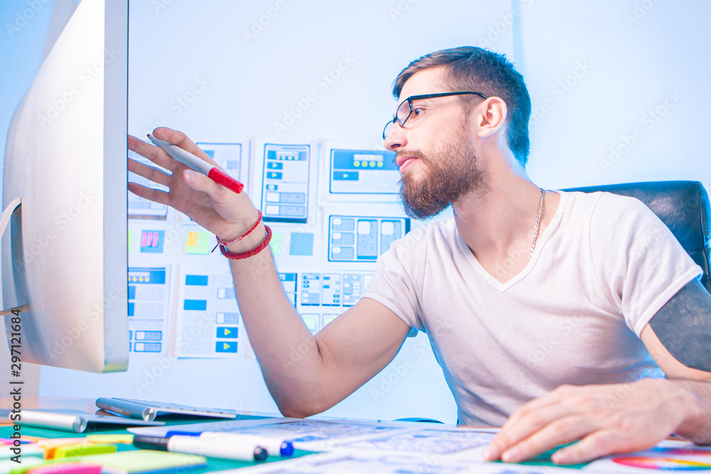 Poster a man in glasses thinks through the user interface of the training program. the young man is passion