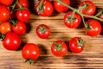 Heap of small cherry tomatoes on wooden table. Top view